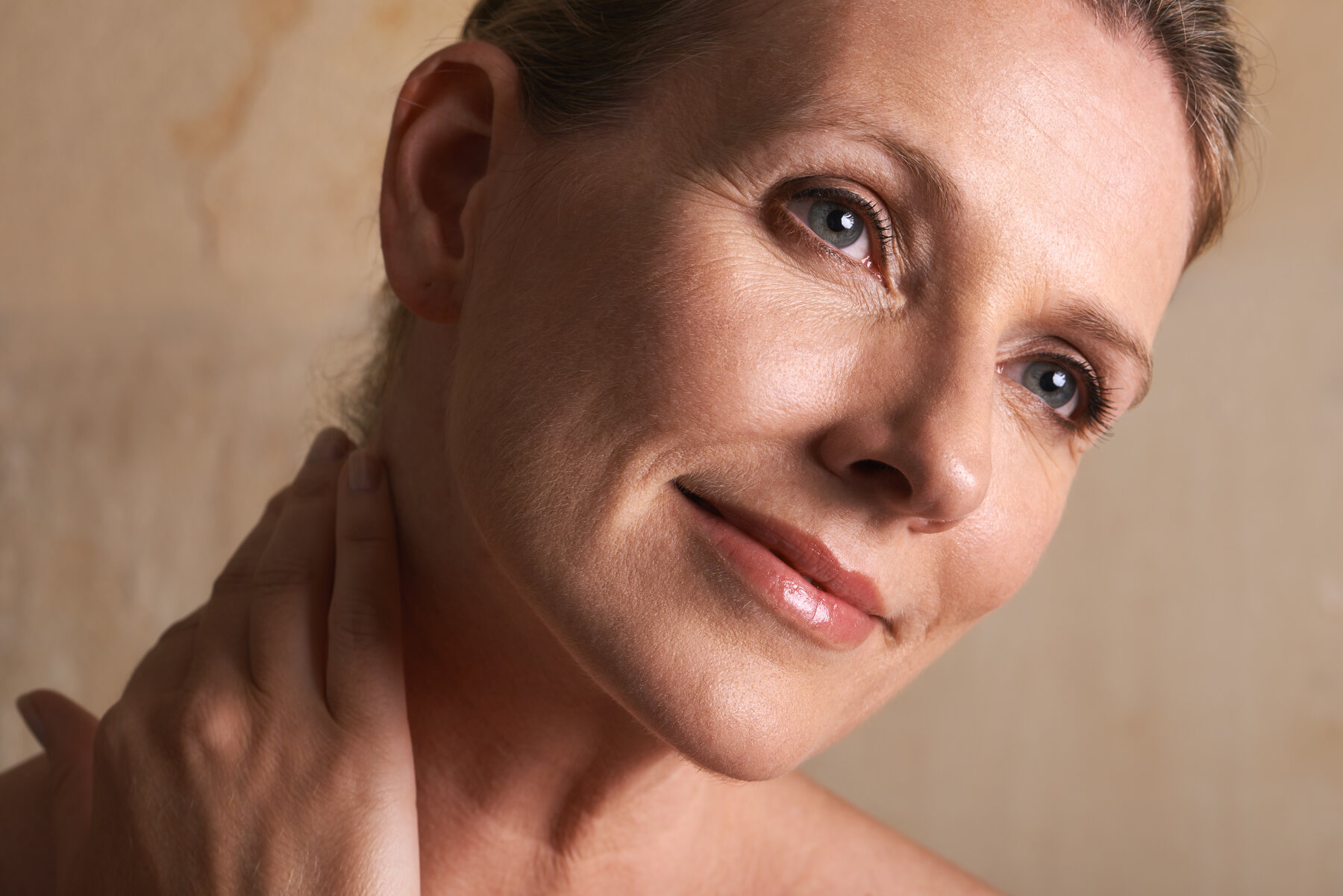 A woman with her hand at her face and her hair back